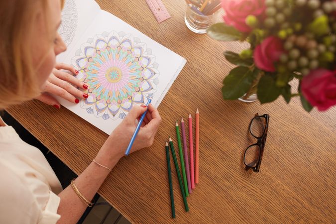 Eye glasses and color pencils on wooden table at home
