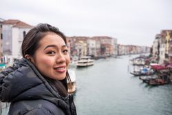 Satisfied Asian resting woman exploring old city with waterways