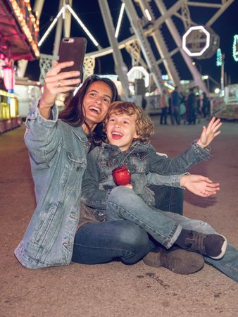 Happy mother and son taking selfie in amusement park