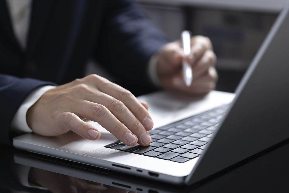 Close-up of a person's hand using a laptop for online shopping