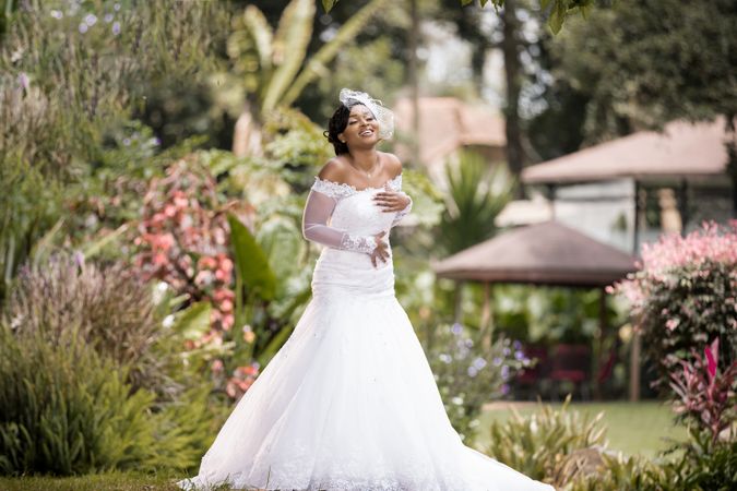 Smiling bride posing in wedding dress in the park