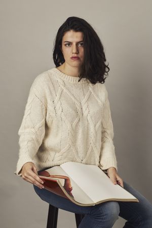Female looking through magazine in studio