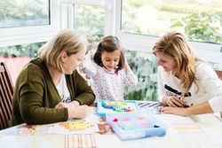 Woman playing board game with daughter and granddaughter