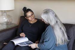 Two women looking at a magazine together