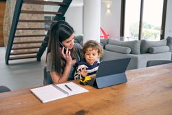 Mother talking through phone while sitting with baby