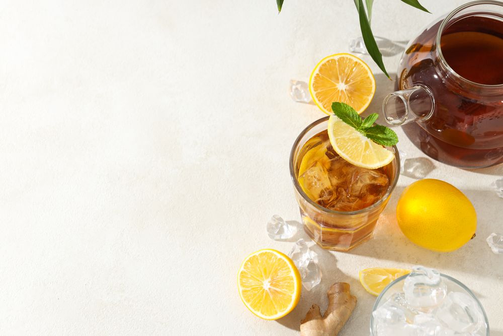 Cold tea with ice, orange slices and mint leaves and ginger
