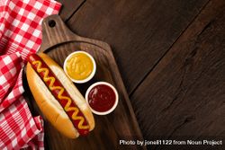 Top view of hot dog with mustard on wooden board and space for text 5o7lm5