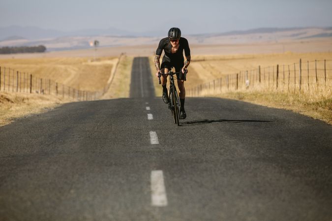 Sportsman cycling on country road