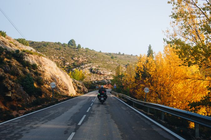 Motocyclist on mountainous road during the fall
