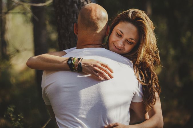 Happy couple embraced in forest