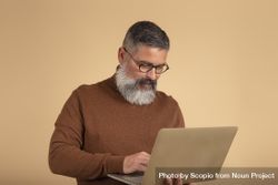 Bearded man in brown sweater using computer 5pKgO0