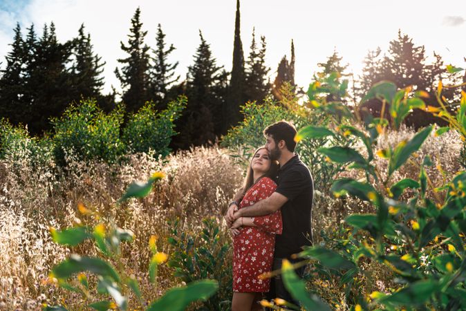Young happy couple embracing in beautiful garden