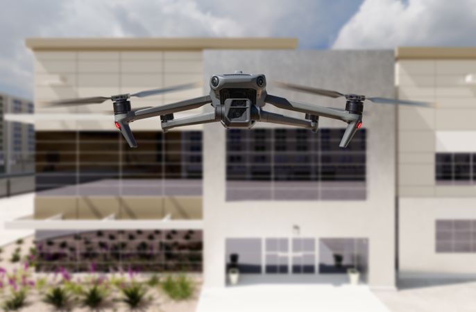 Unmanned Aircraft System Quadcopter Drone UAV In The Air Near Corporate Industrial Building