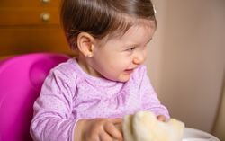 Happy baby laughing and playing with a toy sitting