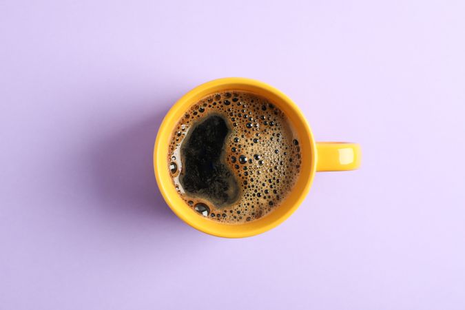 Cup of coffee on color background, space for text