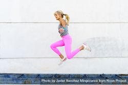 Fit woman in pink leggings doing jumps outside 0JGNKp