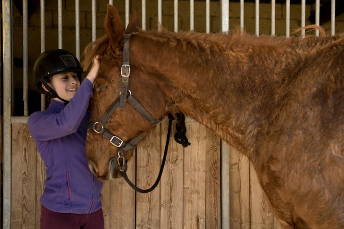 Woman and girl brushing horse