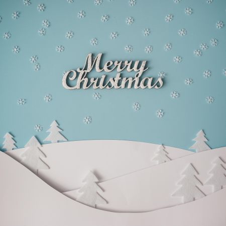 Christmas winter landscape with snowy hills and trees, with the words “Merry Christmas”