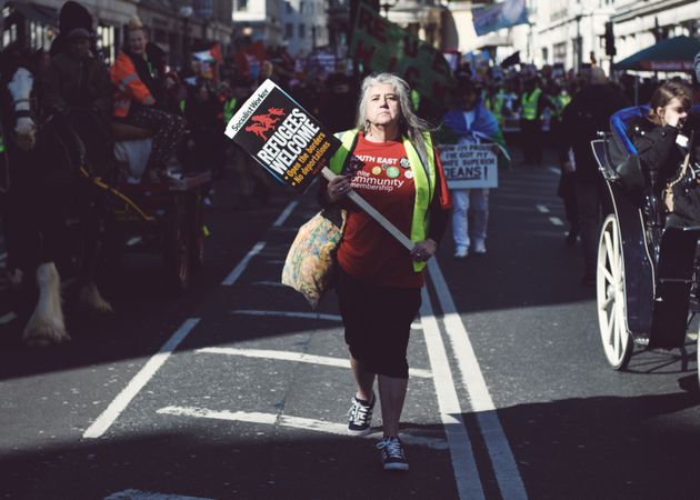 London, England, United Kingdom - March 19 2022: Woman standing tall with “Refugees Welcome” sign