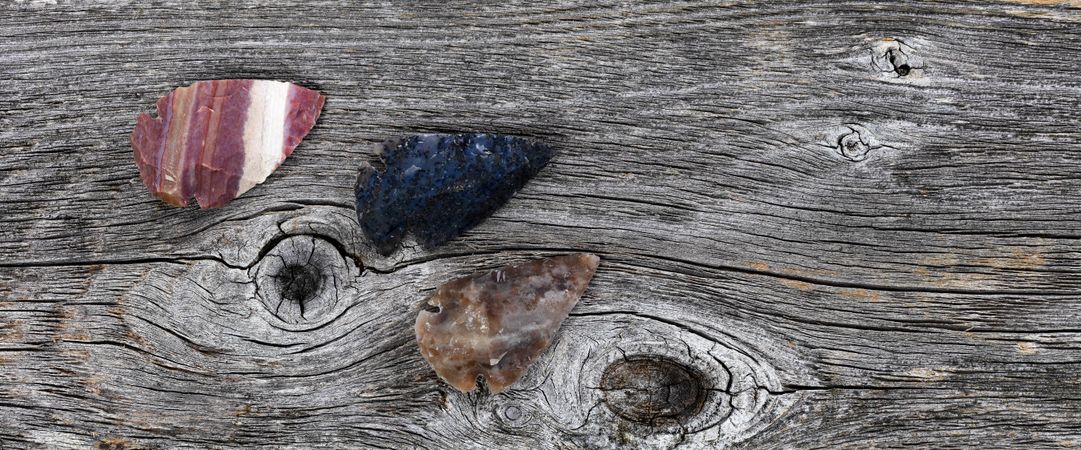 Three stone arrowheads on old wood