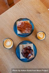 Top view of breakfast roles and cappuccinos on wooden table 5o76k5