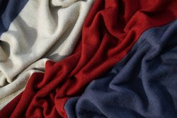 Triple color grey milk and red on knitted fabric wavy crumpled background texture.