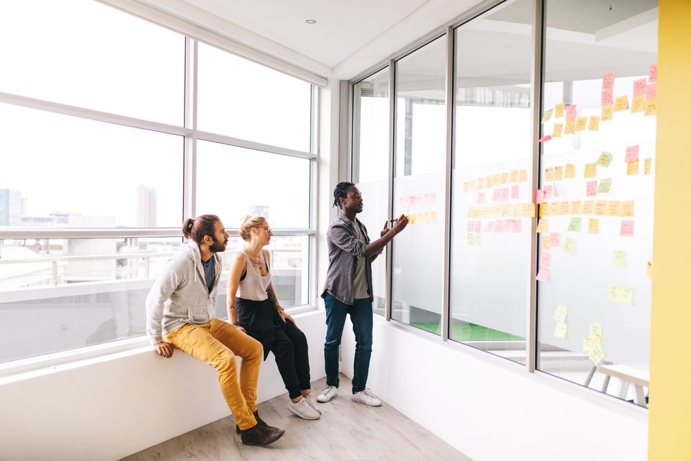 Colleagues working with sticky notes in a bright modern office
