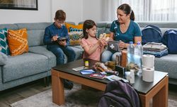 Mother preparing emergency backpack with her children