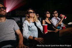 Young women and men watching 3d movie in cinema laughing 0yqaG0