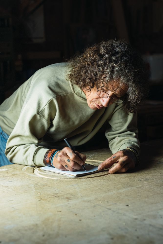 Male carpenter creating sketch in notebook in workshop