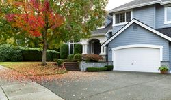 Blue home with two stories and a garage in autumn