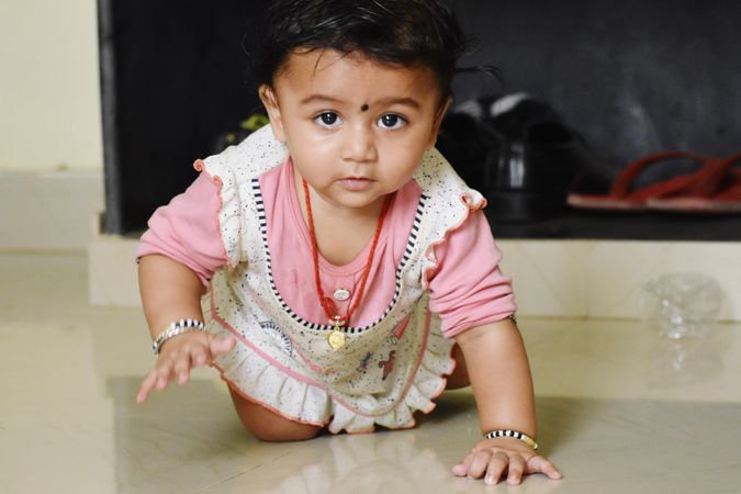 Young Indian girl crawling on the floor