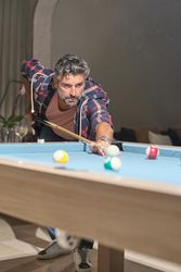 Focused mature Hispanic man playing pool