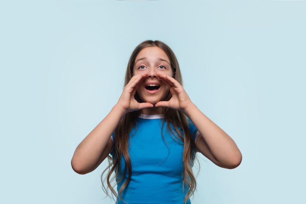 Young girl with hands around mouth, calling out