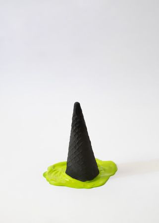 Green ice cream melting under dark cone in halloween concept