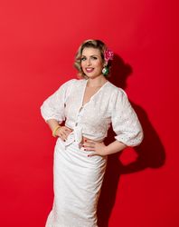 Woman in a summer dress smiling, isolated on a red background