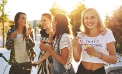 Group of female friends blowing bubbles in the sun