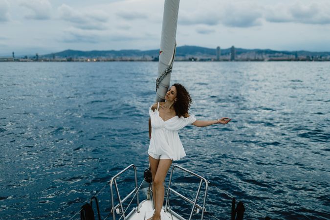 Barefoot bride resting on yacht bow