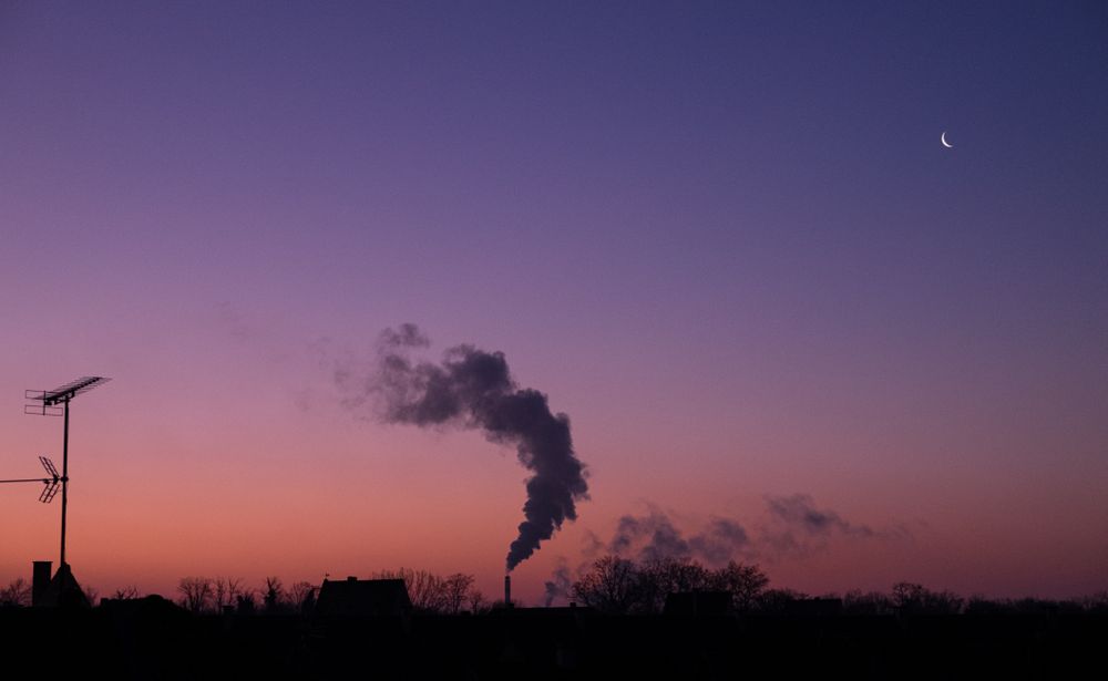 Smoke being discharged into pink purple morning sky