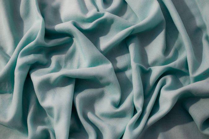 Nude green fabric wavy crumpled background texture with copy space.