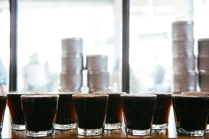 Glasses filled with hot coffee lined up for tasting with copy space