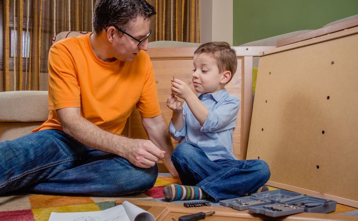 Father and son assembling a new furniture for home
