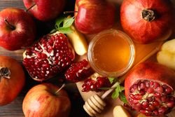 Top view close up of apples and pomegranate with honey