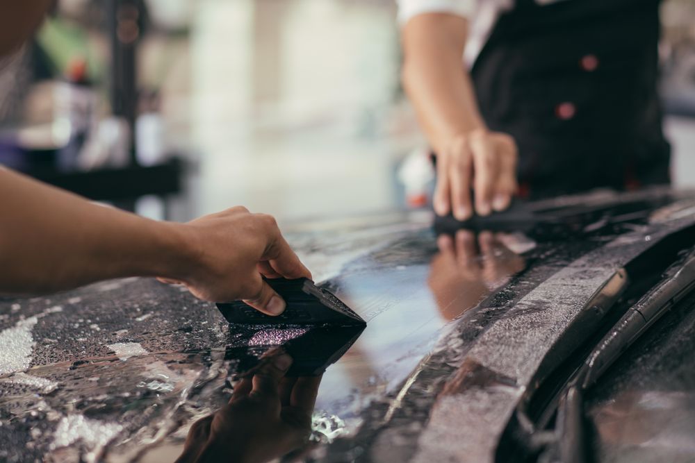 Close up of two men smoothing a car wrap