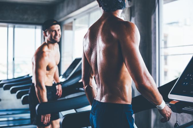 Two men talking on treadmills