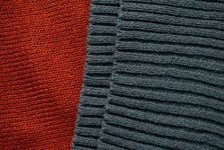 Close up dark grey knitted fabric background texture.