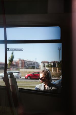 Trendy businesswoman and sunglasses leaning behind bus