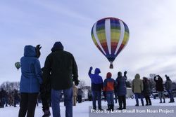 Hudson, WI, USA - February 8th, 2020: People waving at a colorful hot air balloons taking off 0L1Dr5