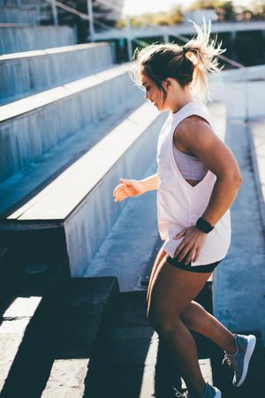 Young woman exercising on stadium stairs