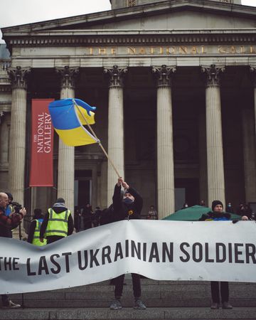 London, England, United Kingdom - March 5 2022: Man waving Ukrainian flag outside in London